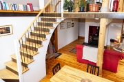 Living area with artistic stairway of County Clare Ecohouse, Ireland