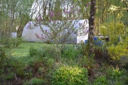 Front garden with polytunnel  of County Clare Ecohouse, Ireland