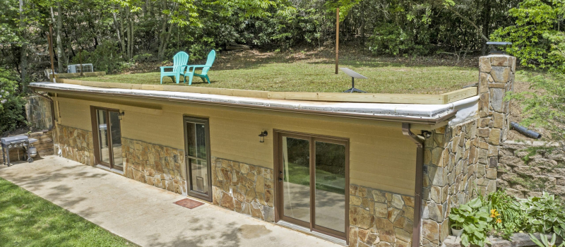 Bermed house showing lawn chairs sitting on the roof.